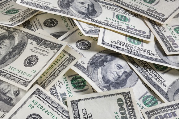 One-hundred-dollar bills laying on top of each other.