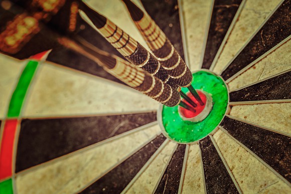 three darts in a dart board's bulls eye.