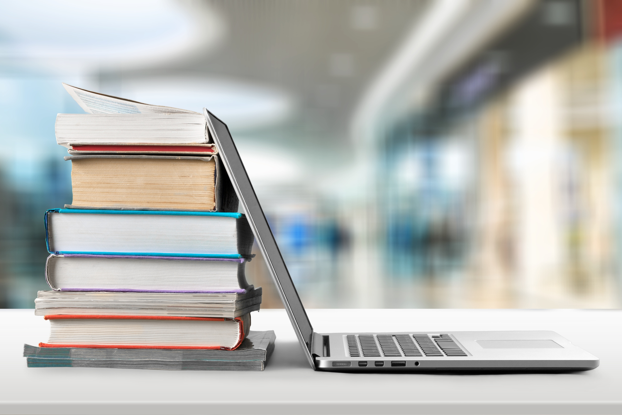 Books stacked next to an open laptop.