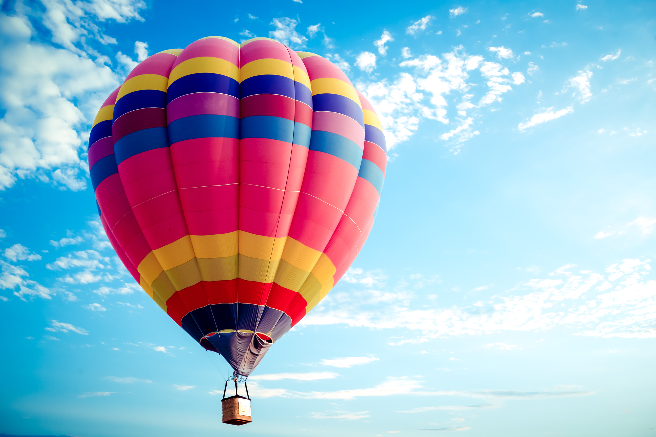 A colorful hot air balloon soars into the sky.