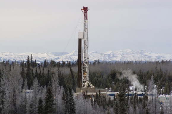 An oil drill against a mountain backdrop