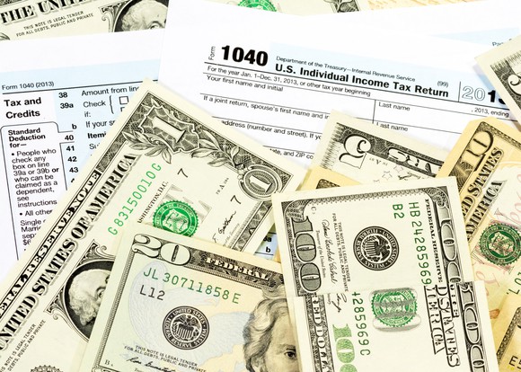 U.S. currency laid ontop of tax forms.