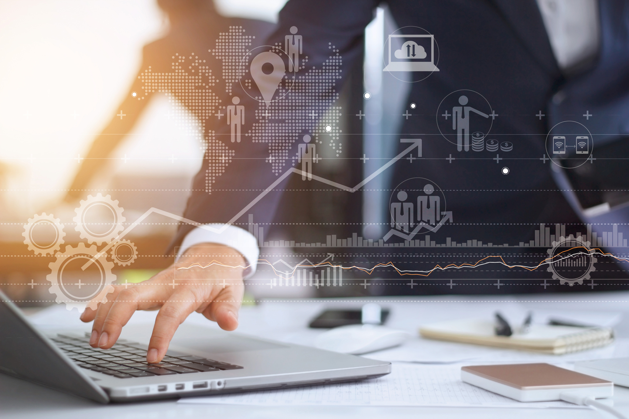 Icons indicating stock growth hover over a laptop.