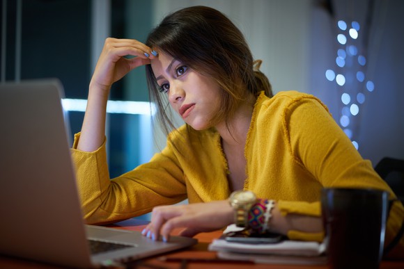 A woman looking at her laptop screen.