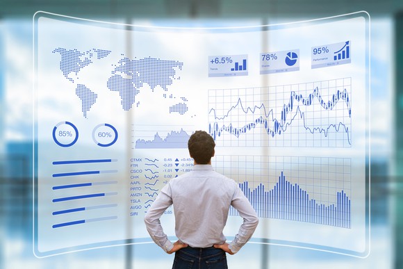 Man looking at futuristic HUD interface with charts, graphs, and data.