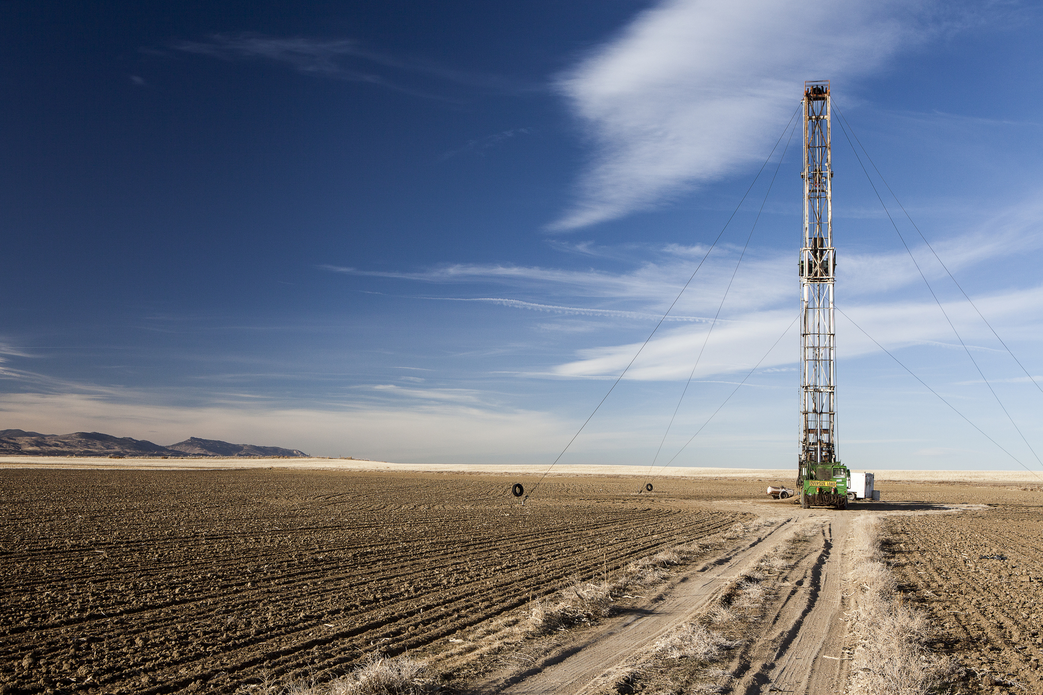 A shale drill in an open plain under a blue sky.