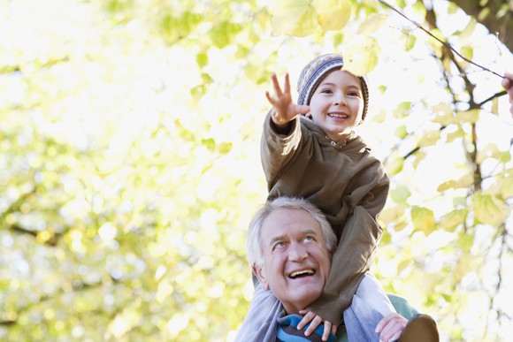 Older man holding a young boy on his shoulders