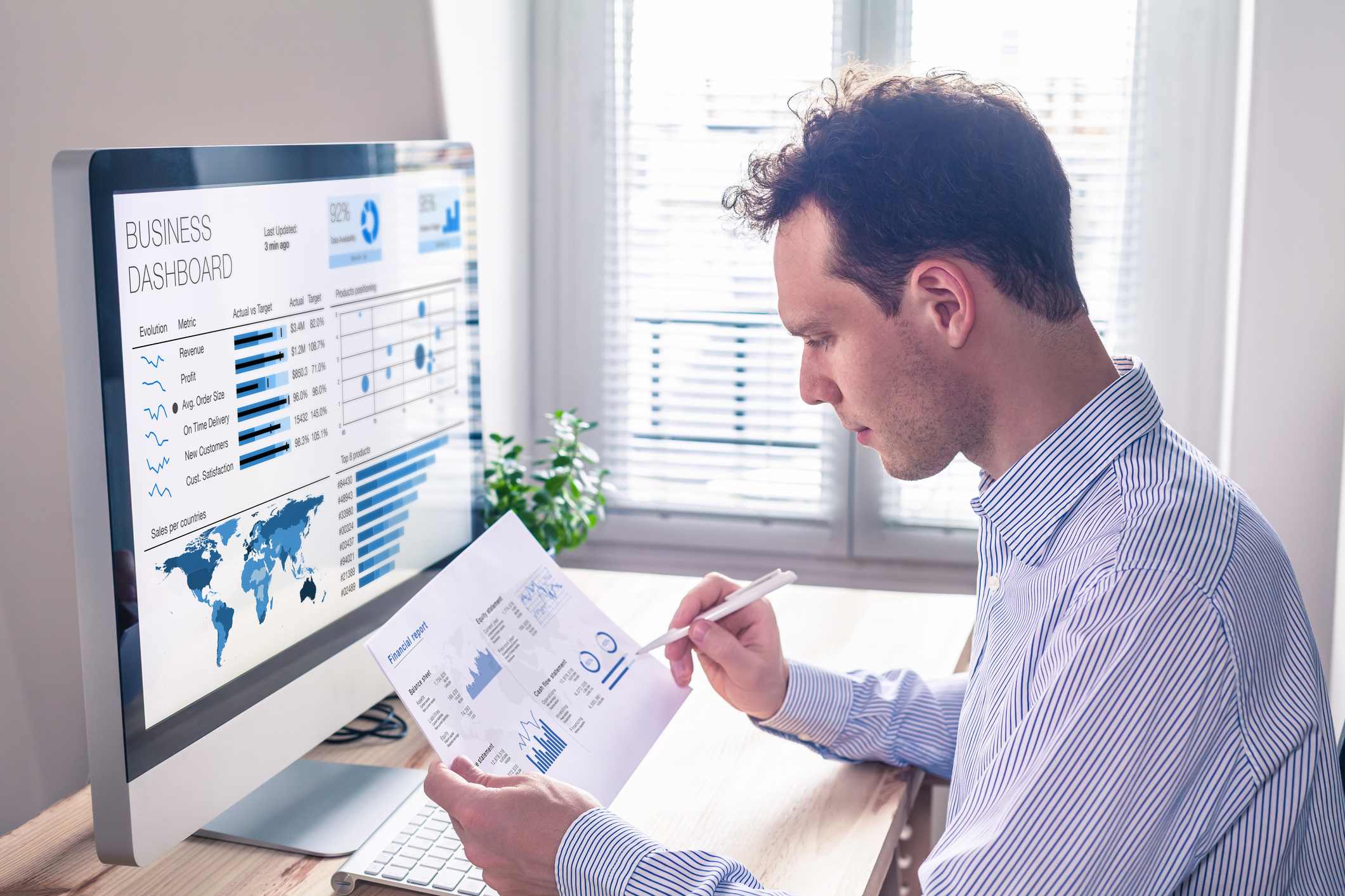 An investor compares a printed chart with data on a computer screen.