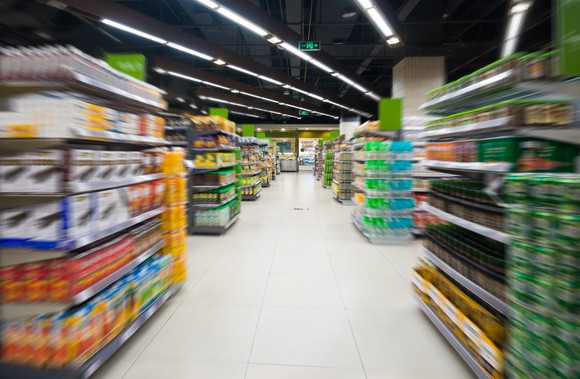 A view down a super market isle shows rows of various food items on either side