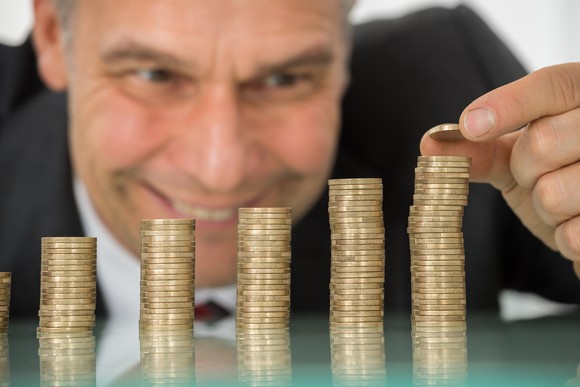 A man happily stacking coins