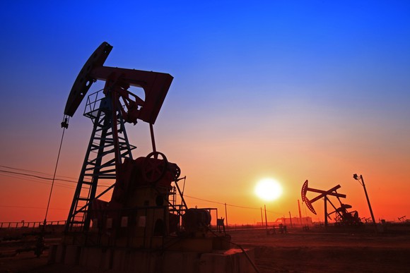 Oil pump on a field at sunset.