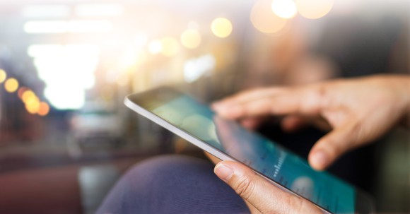 A person using a financial app on a tablet.