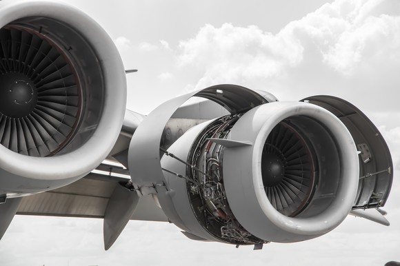An open airplane engine attached to a wing.