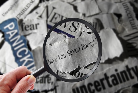 A magnifying glass over the words "Have You Saved Enough" on top of newspaper headlines.