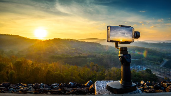 A GoPro camera in the foreground; a sunset/sunrise in the background
