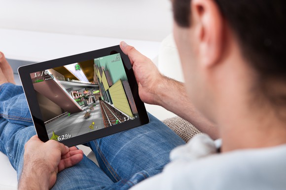 A man playing a video game on a tablet computer.