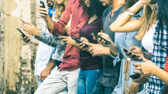 A row of people looking at their phones