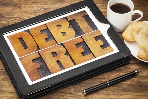The words "debt-free" on an iPad screen on top of a table