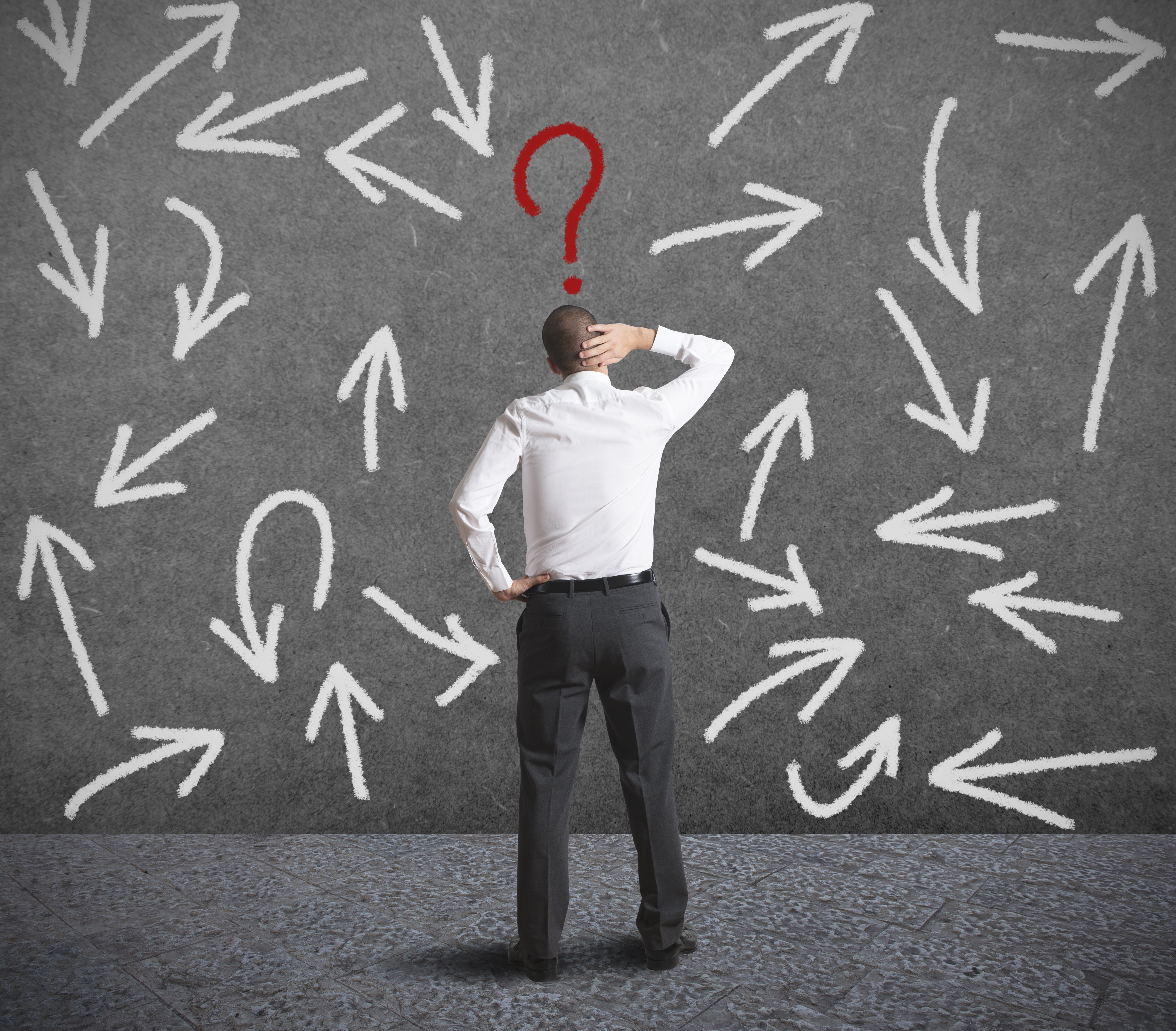 Man standing in front of question marks.