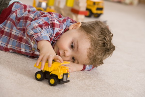 Boy playing with toy truck.
