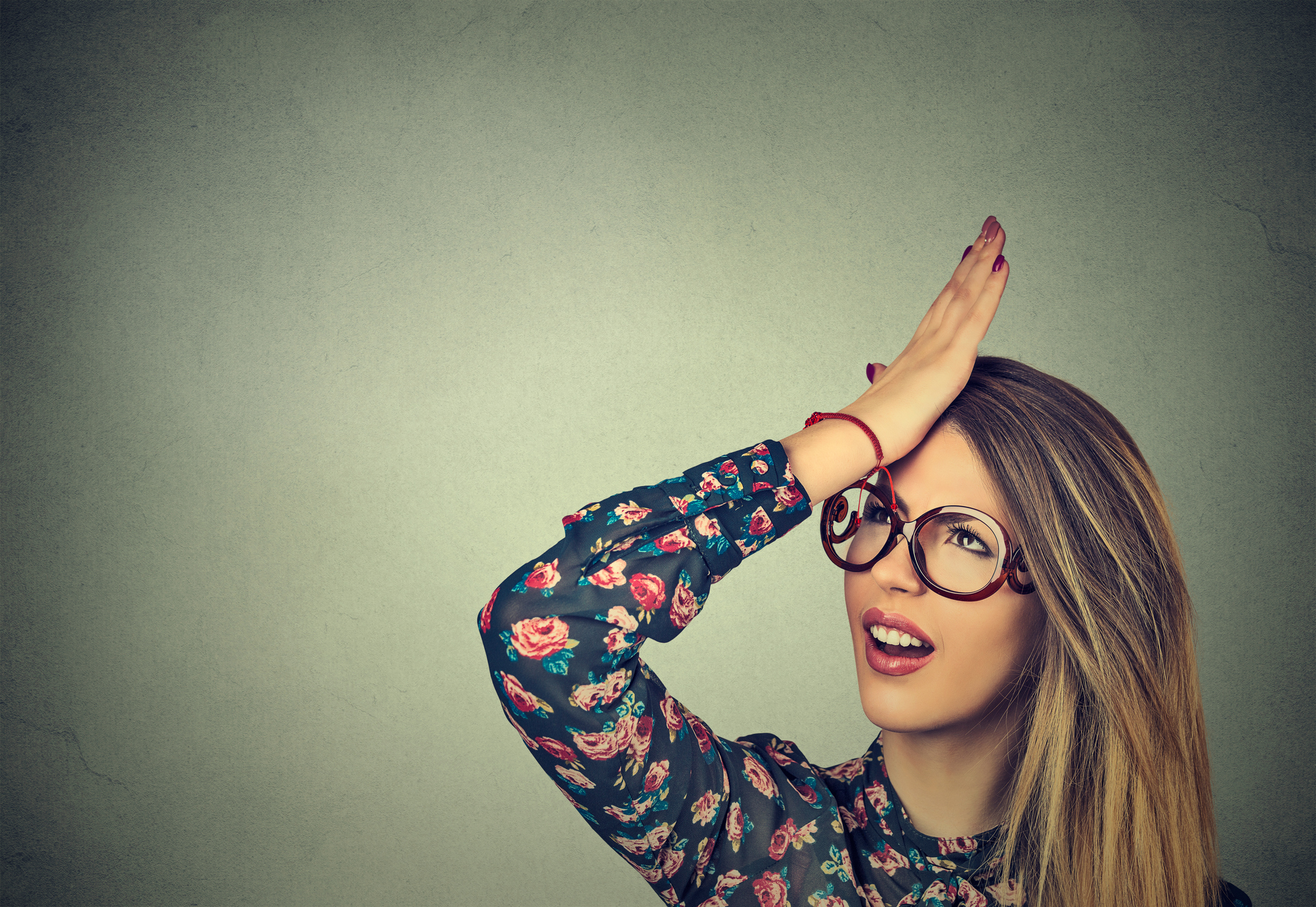 Woman hitting her head with the palm of her hand in disgust