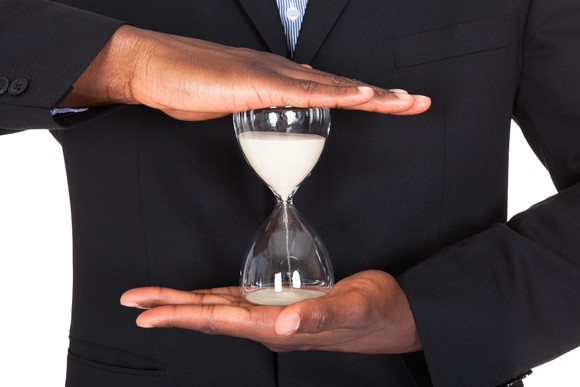 An hourglass held between two hands.