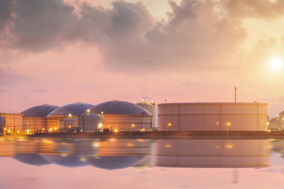 Petroleum product storage tanks reflecting on the water.