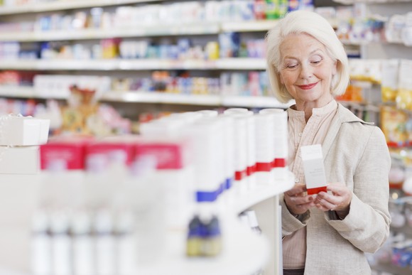 A senior woman is shopping for healthcare supplies at a pharmacy.