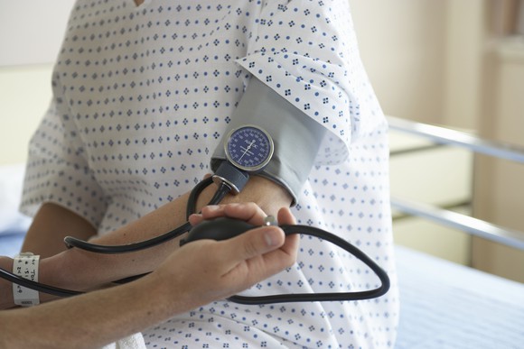 Patient with blood pressure cuff on arm.
