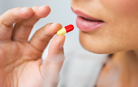 Woman taking an unmarked capsule