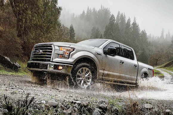 Model-year 2017 Ford F-150 pickup truck splashing through a mud puddle