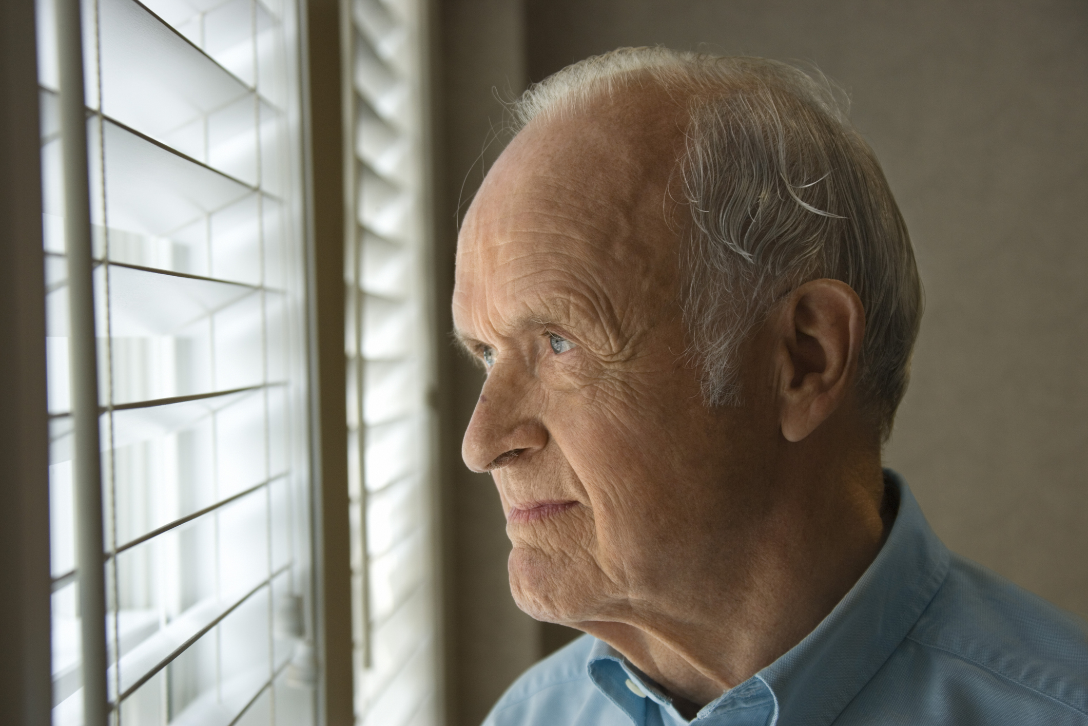 Senior man looking out the window