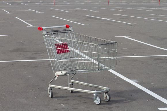 Empty shopping cart in an empty parking lot.