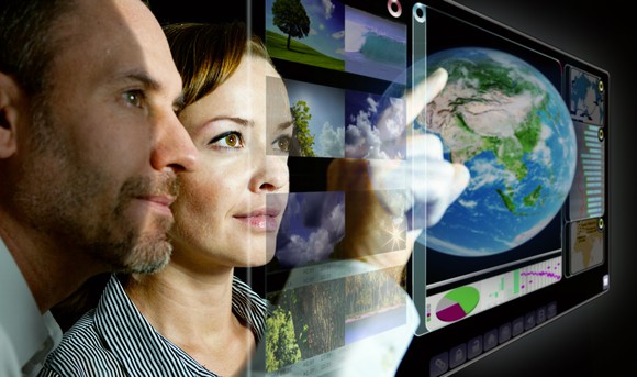 Teamwork in front of a futuristic computer screen