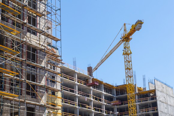 A construction crane building an apartment complex.