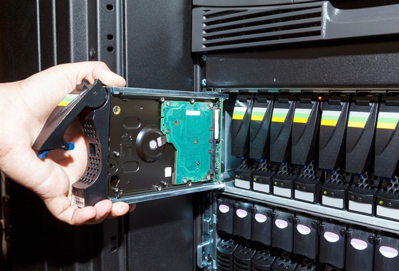 A technician manipulates an enterprise-class hard drive module.