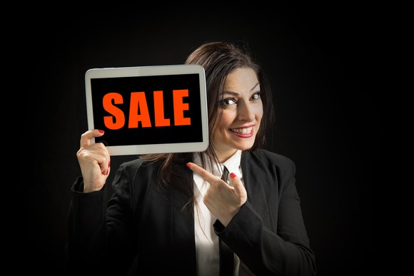 Woman holding sign that says "sale"