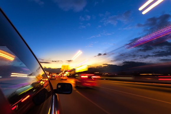 Blurry picture of cars on the road at dusk.