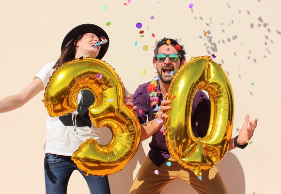 Young couple celebrating with an inflated 3 and 0 - a 30th party