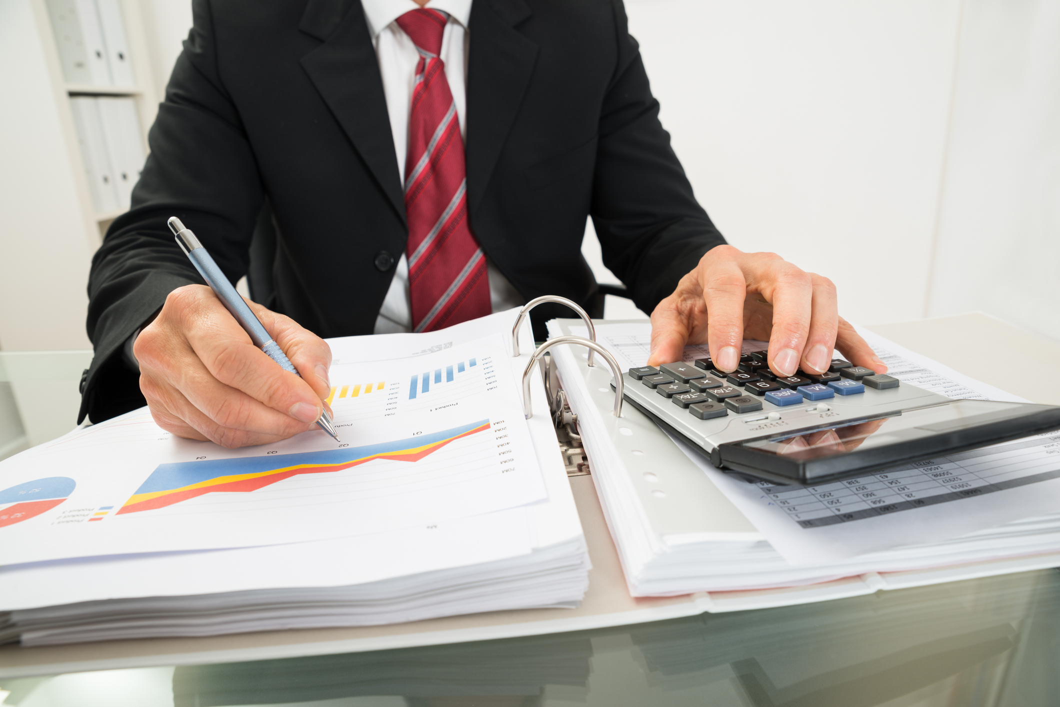 Accountant reviewing paperwork with a calculator.