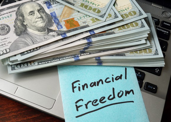 bundles of cash with sign that says financial freedom