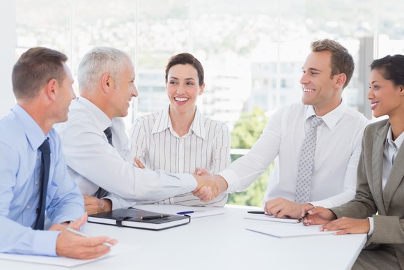 Business people shaking hands and smiling.