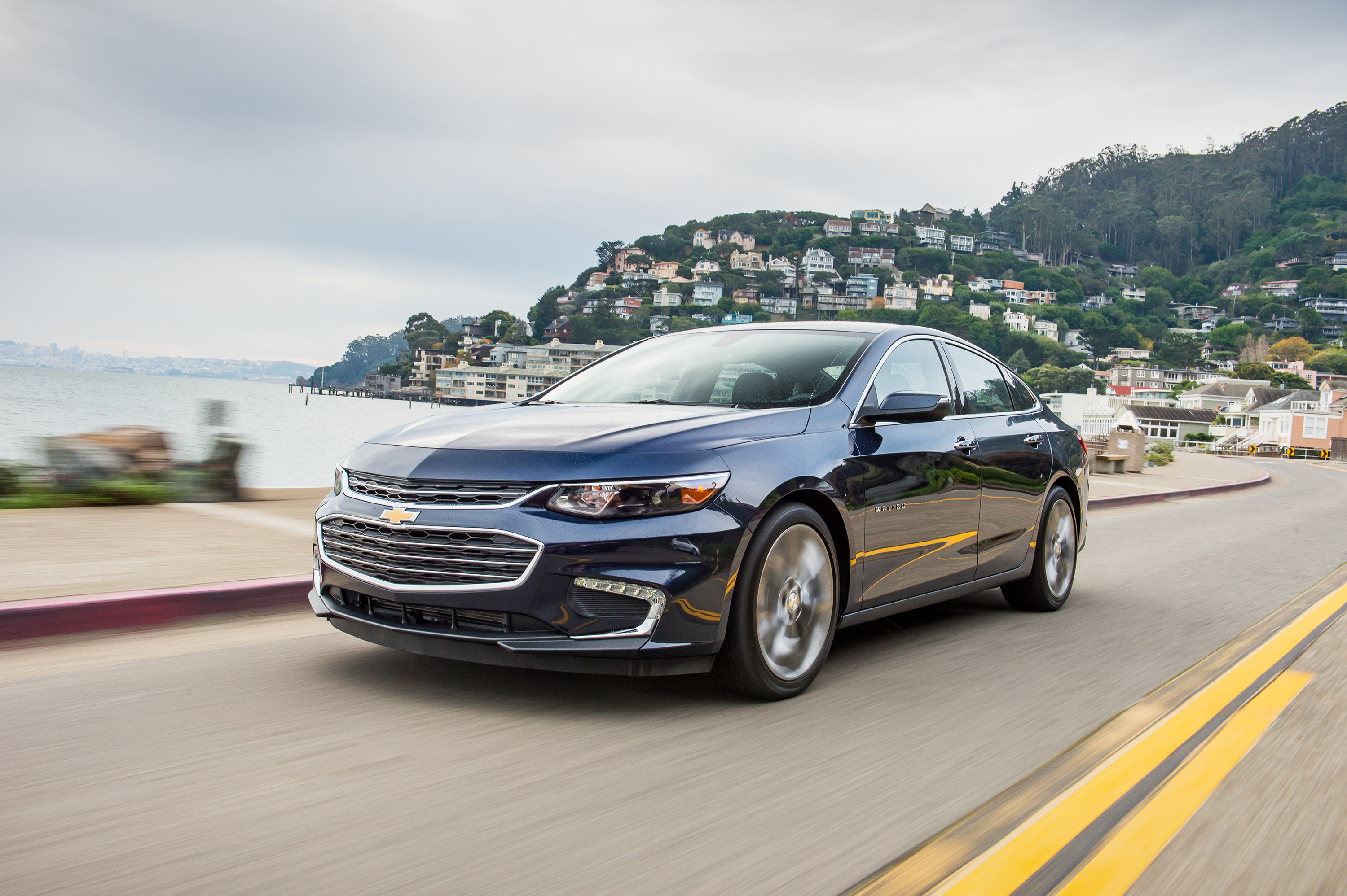 A black 2016 Chevrolet Malibu on a coastal road.