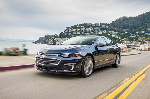 A black 2016 Chevrolet Malibu on a coastal road.