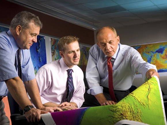 Exxon employees looking at a map.