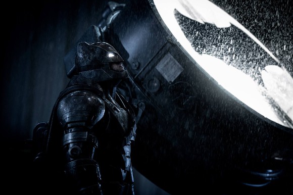 Batman standing in front of a lit-up Bat Signal. Image from "Batman v Superman."