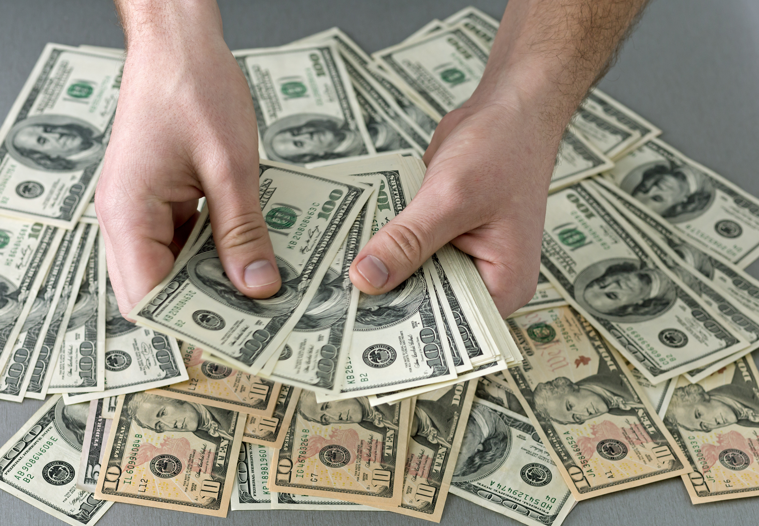 hands holding stacks of bills