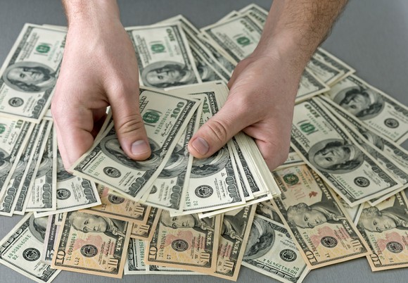 hands holding stacks of bills