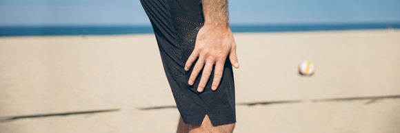 A man wears Lululemon shorts on the beach.