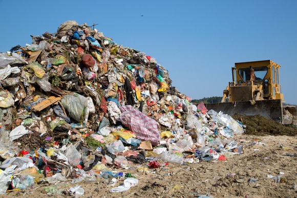 Bulldozer moving trash at a landfill. Bulldozer moving trash at a landfill.